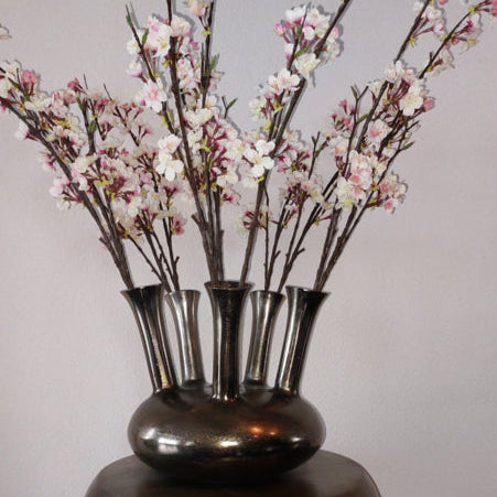 Aluminium toetervaas in antiek nikkel met trompetvorm – decoratieve vaas van gegoten metaal, geschikt voor droogbloemen of kunsttakken.