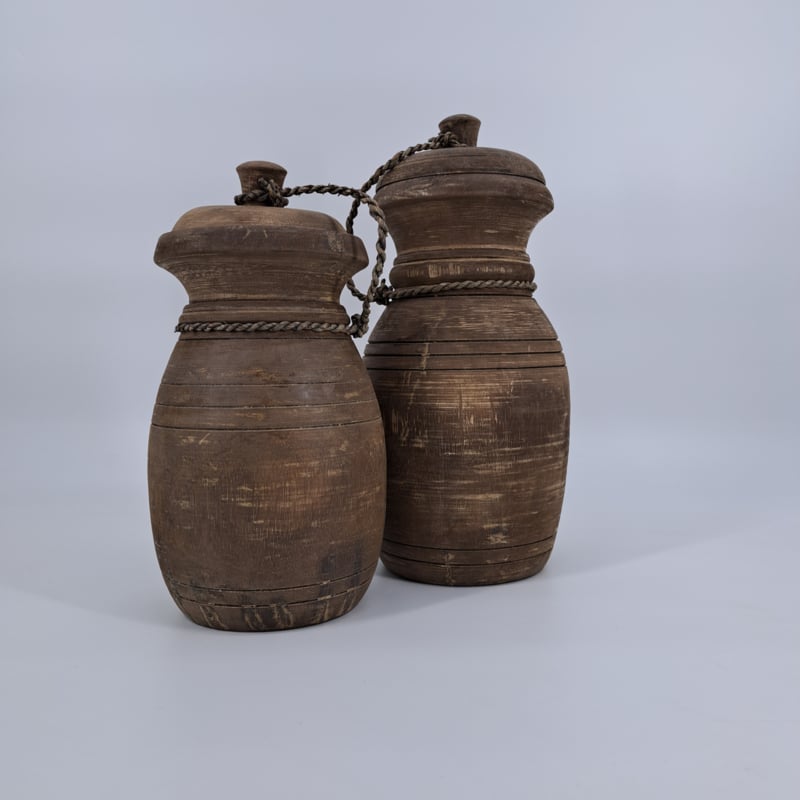 Een kleine, robuuste houten pot met deksel, perfect voor landelijke decoratie.
