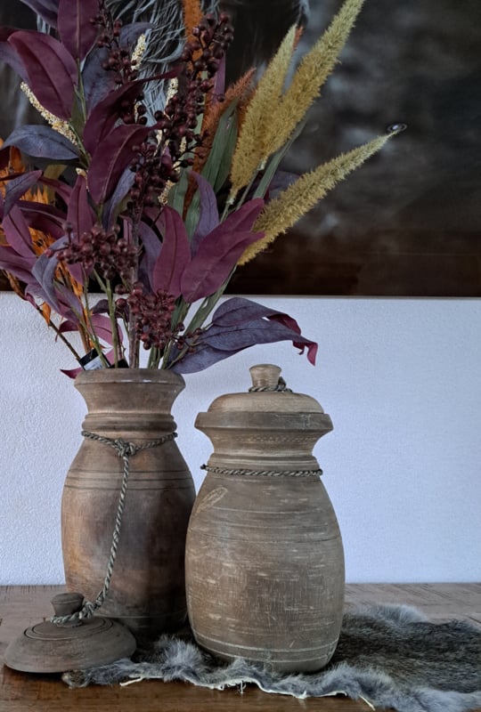 Een kleine, robuuste houten pot met deksel, perfect voor landelijke decoratie.