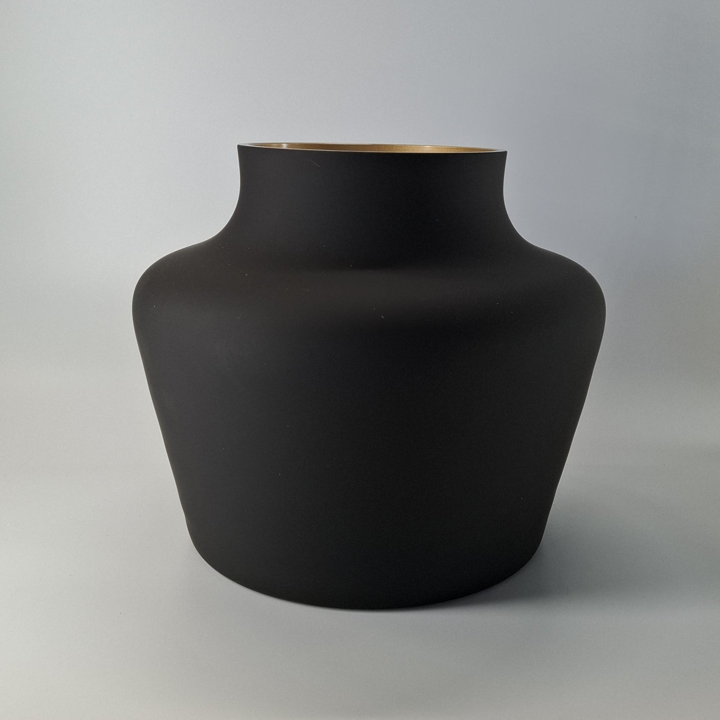 Mondgeblazen zwarte vaas met een luxe gouden binnenkant. Elegant en stijlvol, perfect voor decoratie op een dressoir, tafel of keukenblad. Afmetingen: H22 x Ø22,5 cm."
