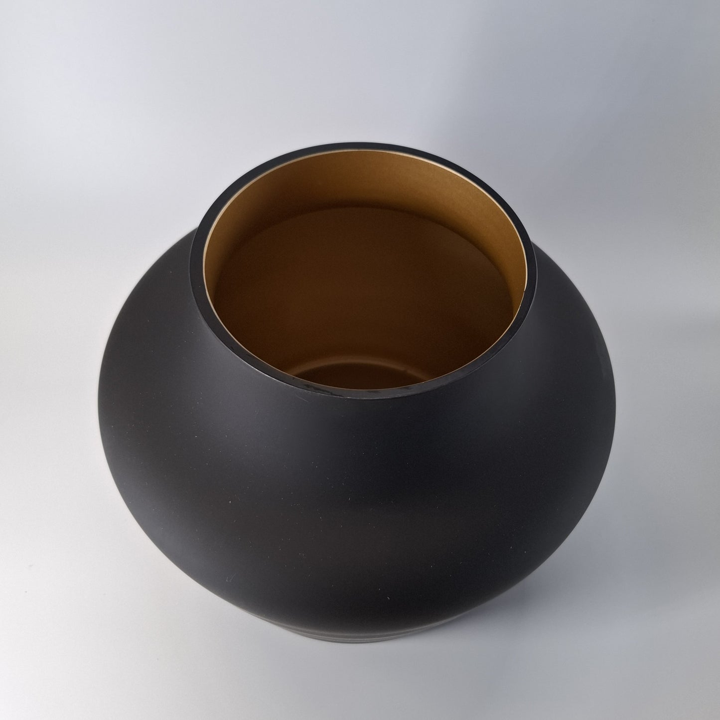 Mondgeblazen zwarte vaas met een luxe gouden binnenkant. Elegant en stijlvol, perfect voor decoratie op een dressoir, tafel of keukenblad. Afmetingen: H22 x Ø22,5 cm."