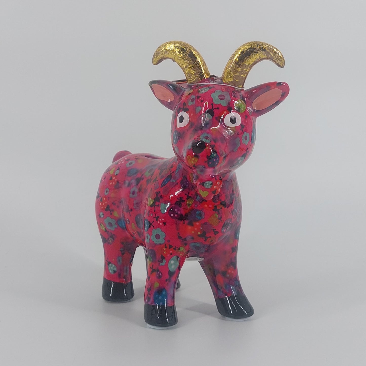 Pomme Pidou spaarpot geit Gabriel in roze met lieveheersbeestjes. Keramische spaarpot met speels design, ideaal als cadeau of decoratie. Afmetingen: L19 x D8.5 x H20cm."