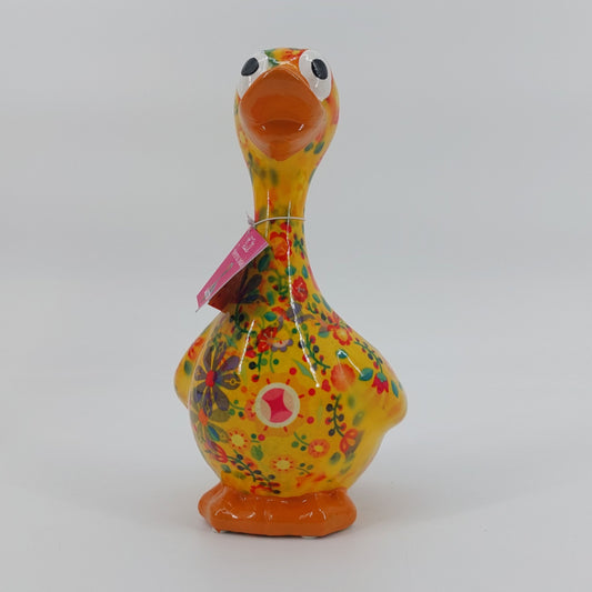 Een stijlvolle keramieken spaarpot in de vorm van een gans, Gaston. Zijn levendige gele kleur en speelse bloemenpatroon maken hem een unieke toevoeging aan elk interieur. Ideaal als decoratief item én om geld in te sparen.