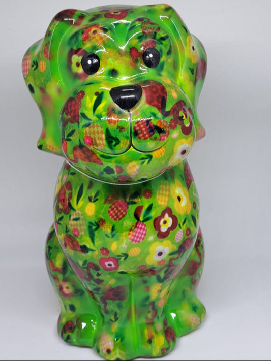 Keramische Pomme Pidou spaarpot in de vorm van een hond, groen met flamingo's en bloemen. Afmetingen: L9 x B10 x H20 cm. Een speels en origineel cadeau-idee."