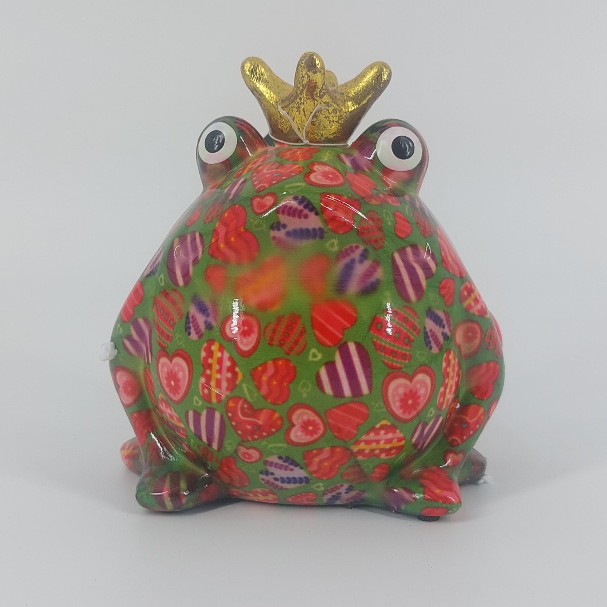Een speelse keramieken spaarpot in de vorm van een kikker, Freddy. Met zijn levendige groene kleur en hartjespatroon brengt hij een vrolijke sfeer in elke ruimte. Perfect als decoratief item én om geld in te sparen.