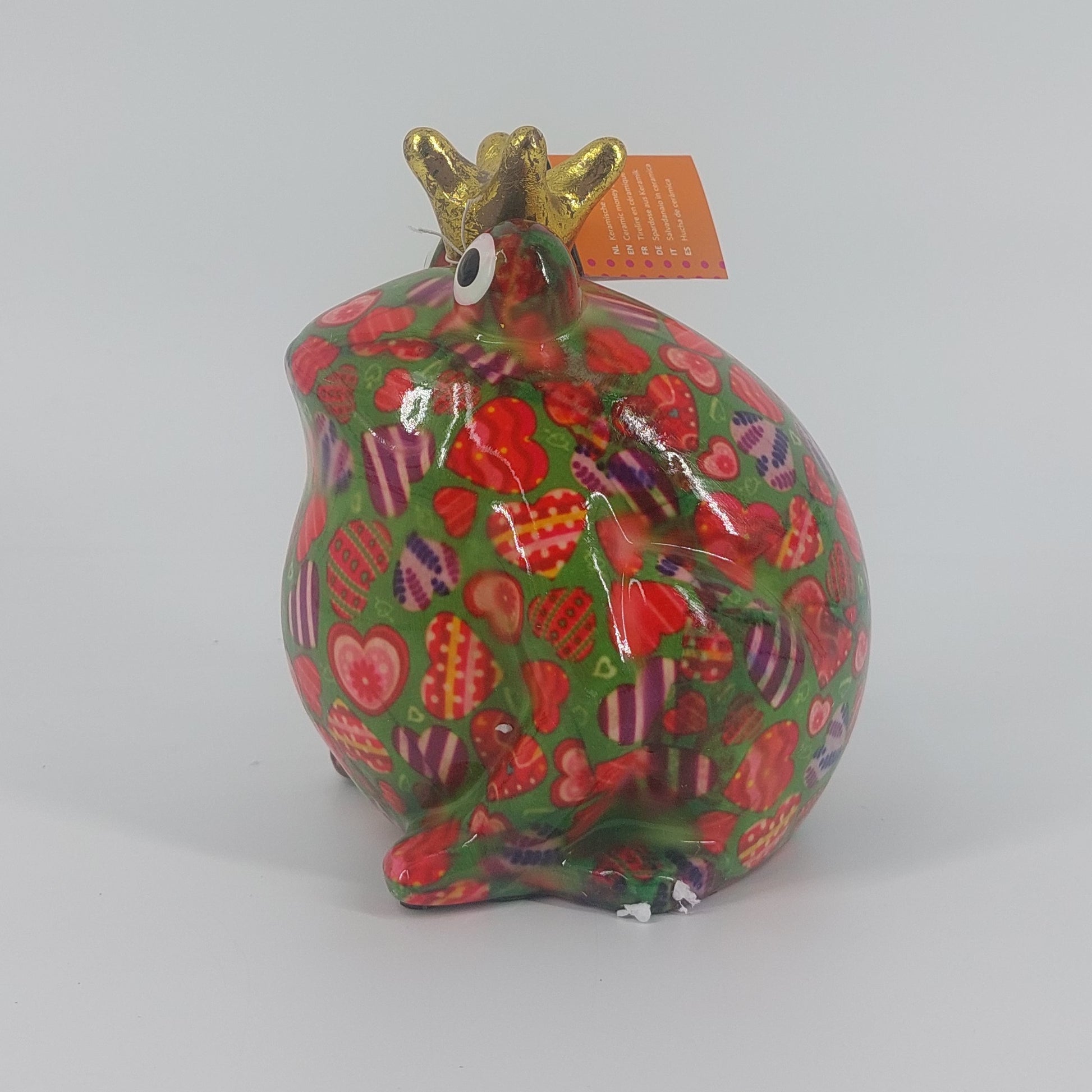Een speelse keramieken spaarpot in de vorm van een kikker, Freddy. Met zijn levendige groene kleur en hartjespatroon brengt hij een vrolijke sfeer in elke ruimte. Perfect als decoratief item én om geld in te sparen.