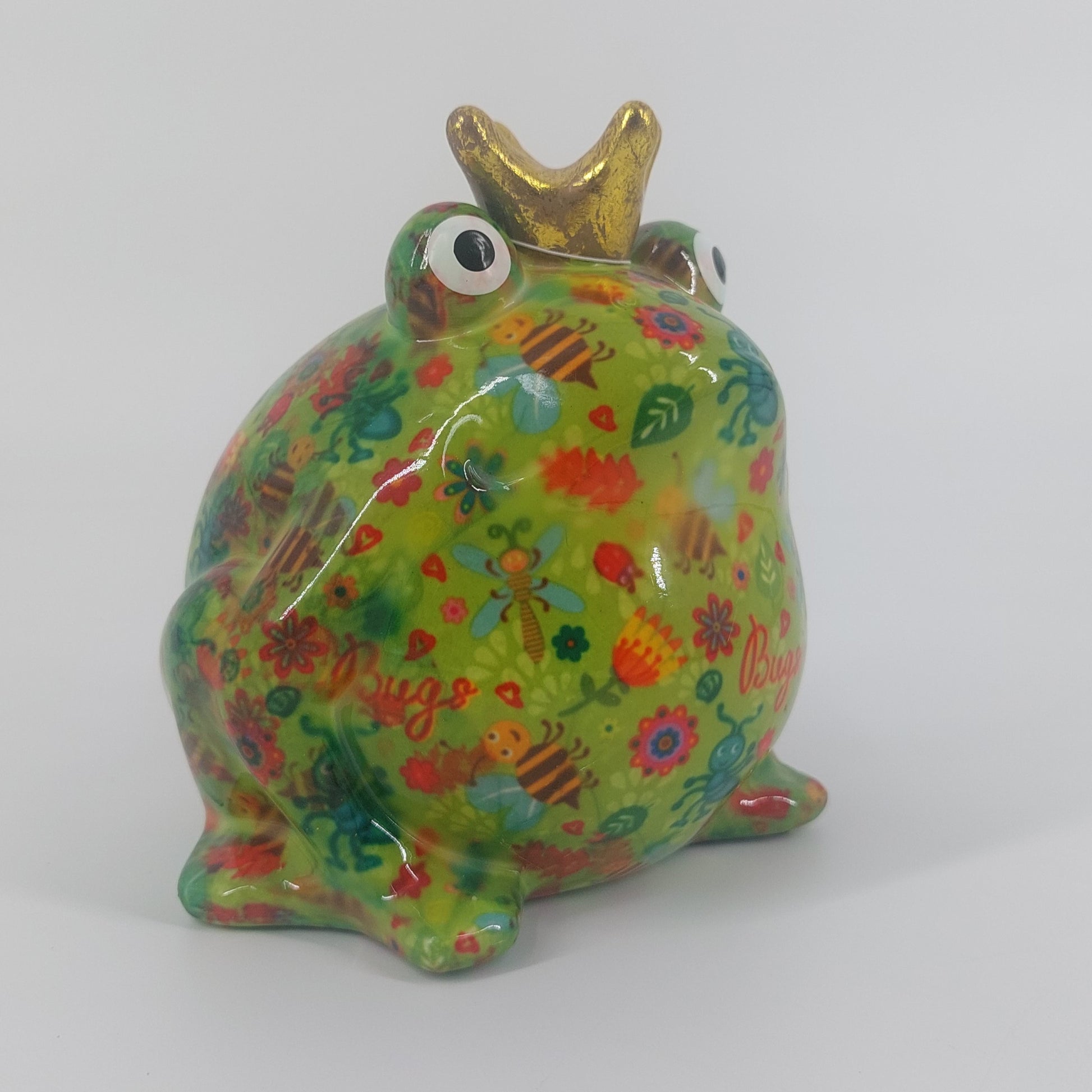 Een vrolijke keramieken spaarpot in de vorm van een kikker, Freddy. Met zijn groene kleur en speelse insectenmotief brengt hij een unieke charme in elke ruimte. Ideaal als decoratie én om geld in te sparen.