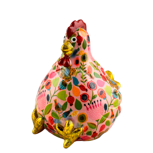 Roze keramische Pomme Pidou spaarpot kip Claire met speelse bloemenprint. Een vrolijke en stijlvolle manier om geld te sparen, perfect als cadeau of decoratief item."