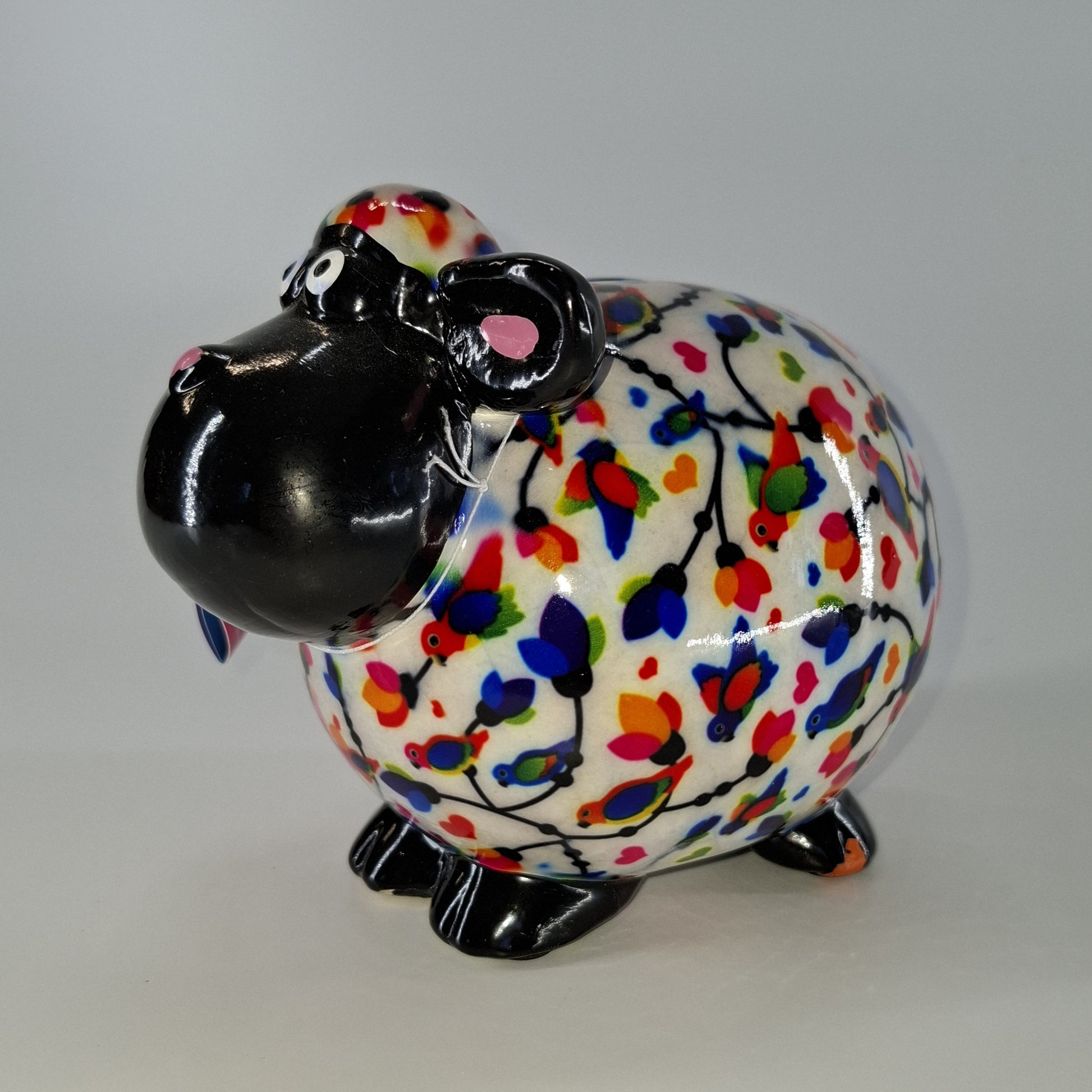 Keramische Pomme Pidou spaarpot in de vorm van een schaap, wit met vogels. Afmetingen: L17 x B11 x H14 cm. Een speels en origineel cadeau-idee."