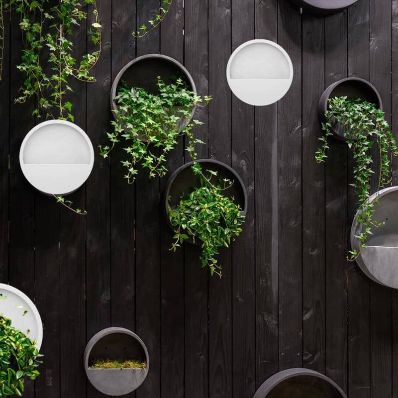 Een stijlvolle, ronde hangende bloempot van Pottery Pots, gemaakt van duurzaam fiberstone in een elegante mat witte kleur. Perfect voor zowel binnen als buiten, ideaal voor het toevoegen van een groene touch aan muren zonder extra vloerruimte in beslag te nemen."