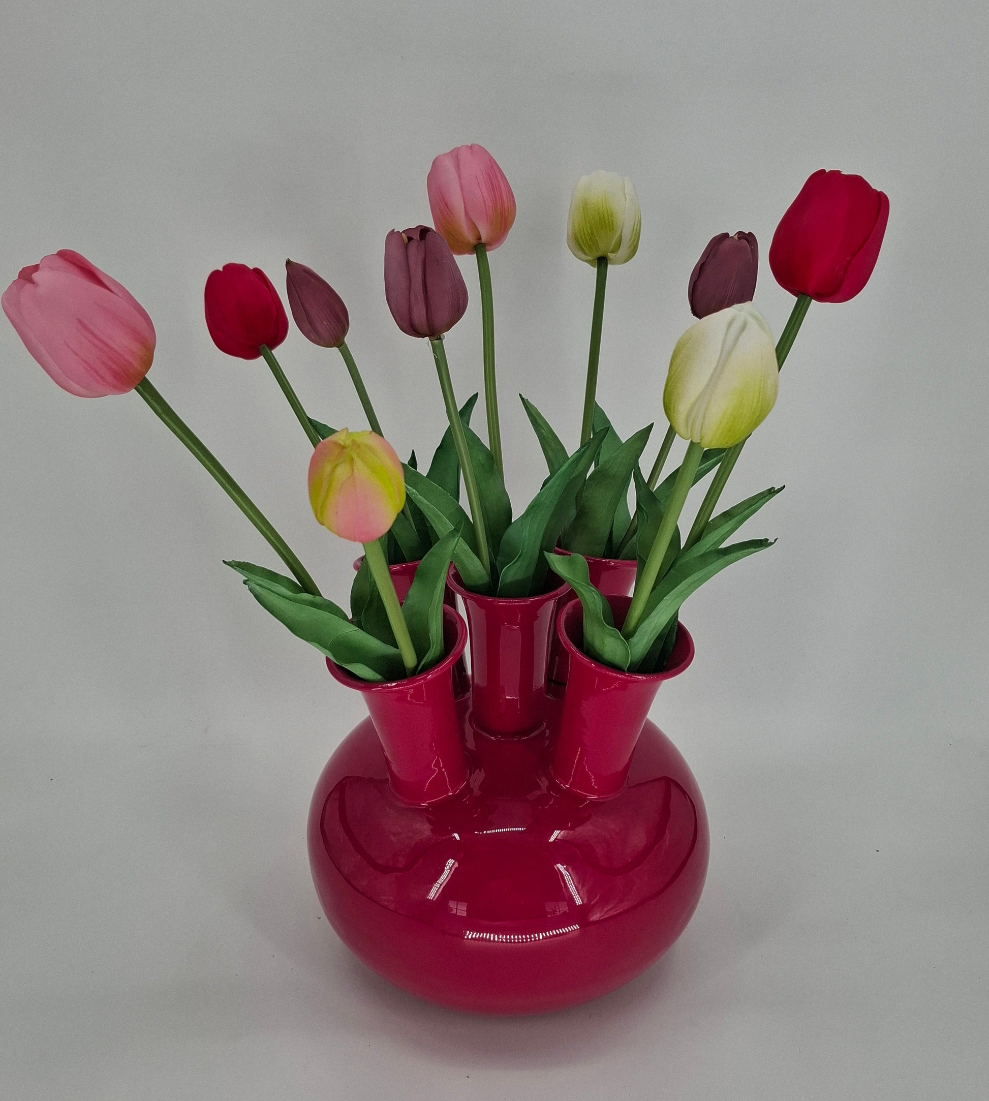 Decoratieve tulpenvaas van metaal in fuchsia kleur, ideaal als woonaccessoire of cadeau.