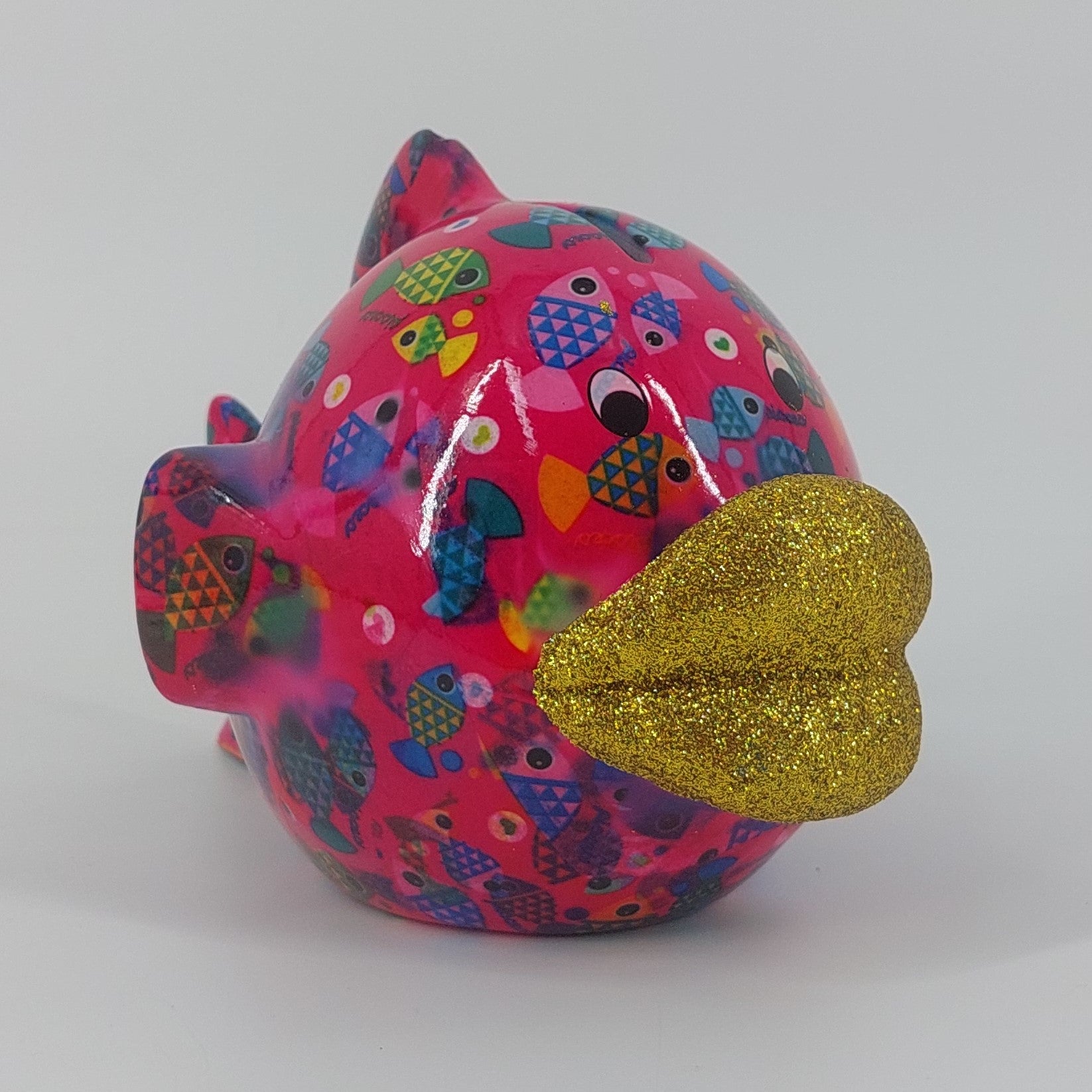 Pomme Pidou spaarpot vis Kelly in fuchsia met visjes. Keramische spaarpot met speels design, ideaal als cadeau of decoratie. Afmetingen: L14 x D21 x H13.5cm