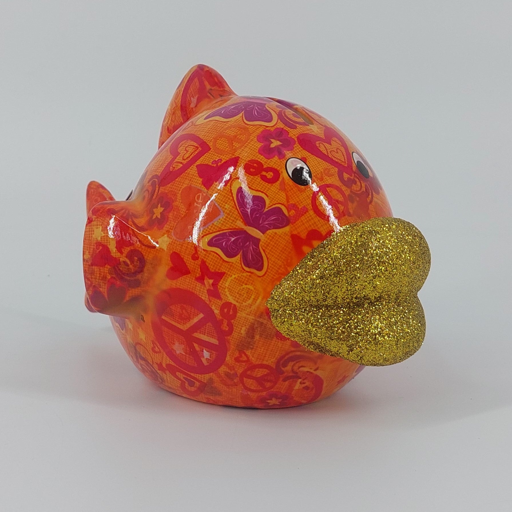 "Pomme Pidou spaarpot vis Kelly in oranje met figuurtjes. Keramische spaarpot met speels design, ideaal als cadeau of decoratie. Afmetingen: L14 x D21 x H13.5cm."