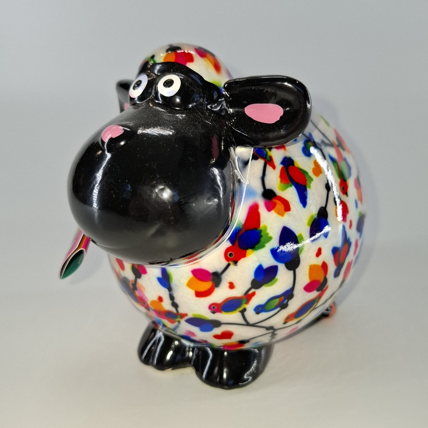Keramische Pomme Pidou spaarpot in de vorm van een schaap, wit met vogels. Afmetingen: L17 x B11 x H14 cm. Een speels en origineel cadeau-idee."