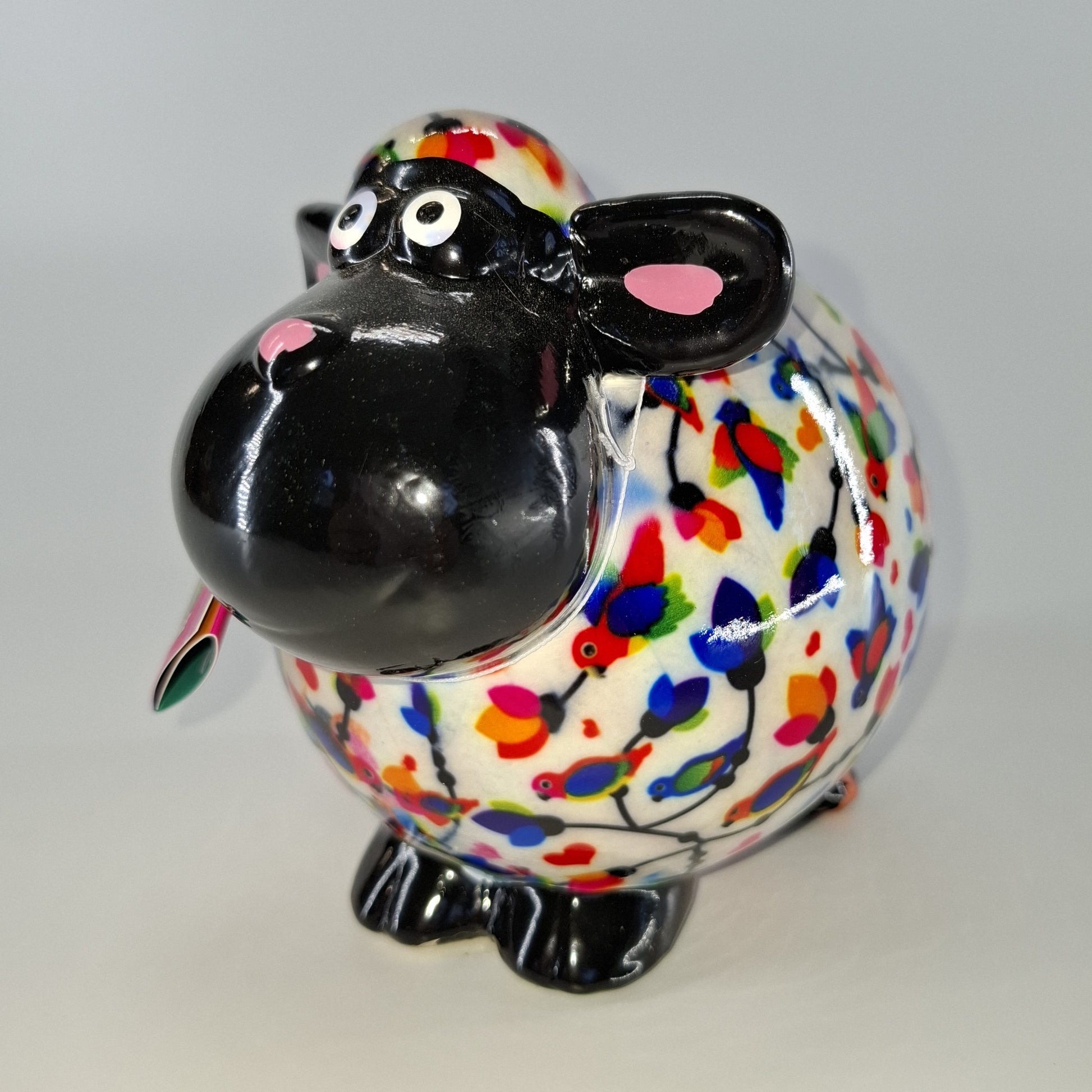 Keramische Pomme Pidou spaarpot in de vorm van een schaap, wit met vogels. Afmetingen: L17 x B11 x H14 cm. Een speels en origineel cadeau-idee."