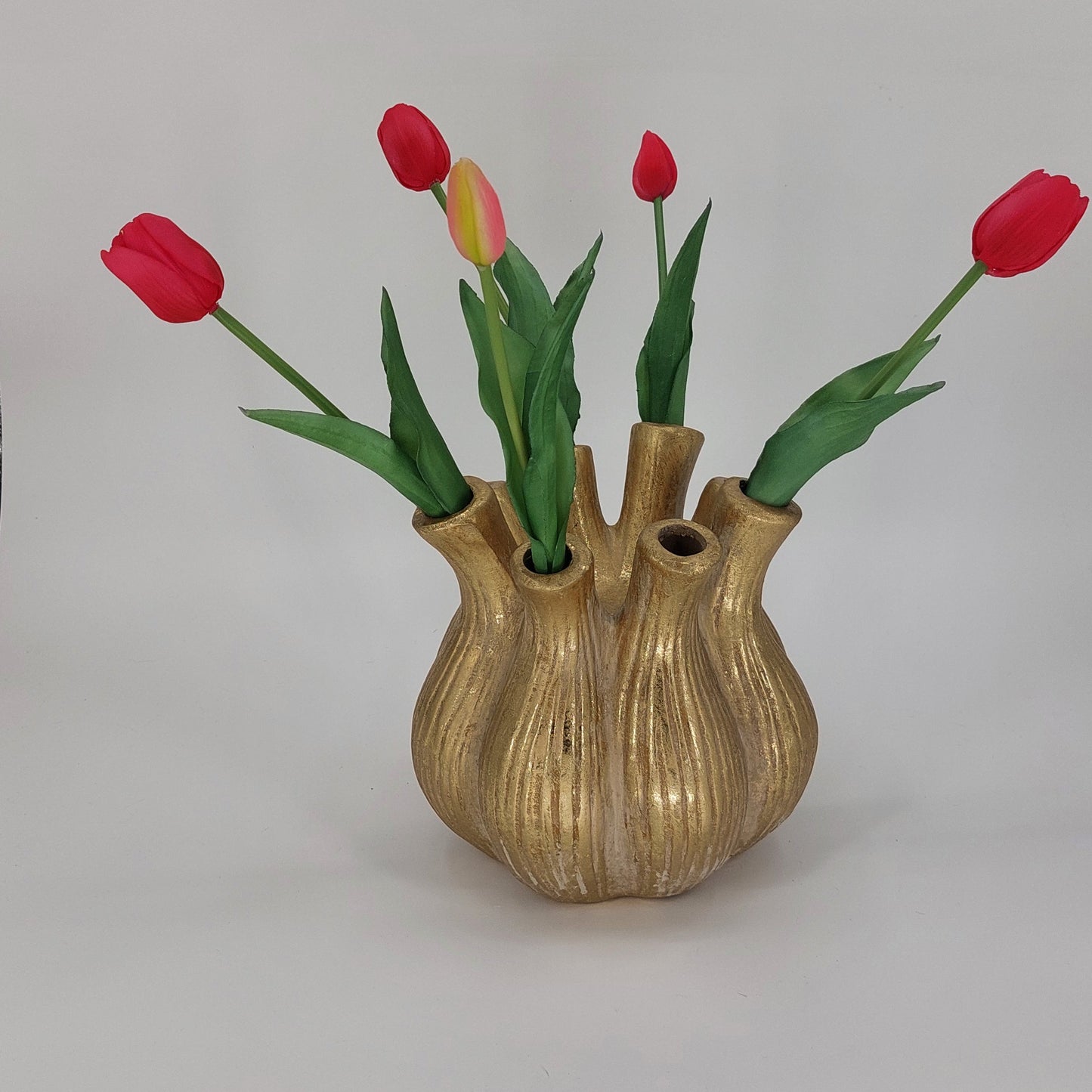 Ronde gouden tulpenvaas van keramiek met acht tuiten, geschikt voor bloemstukken, op een neutrale achtergrond”